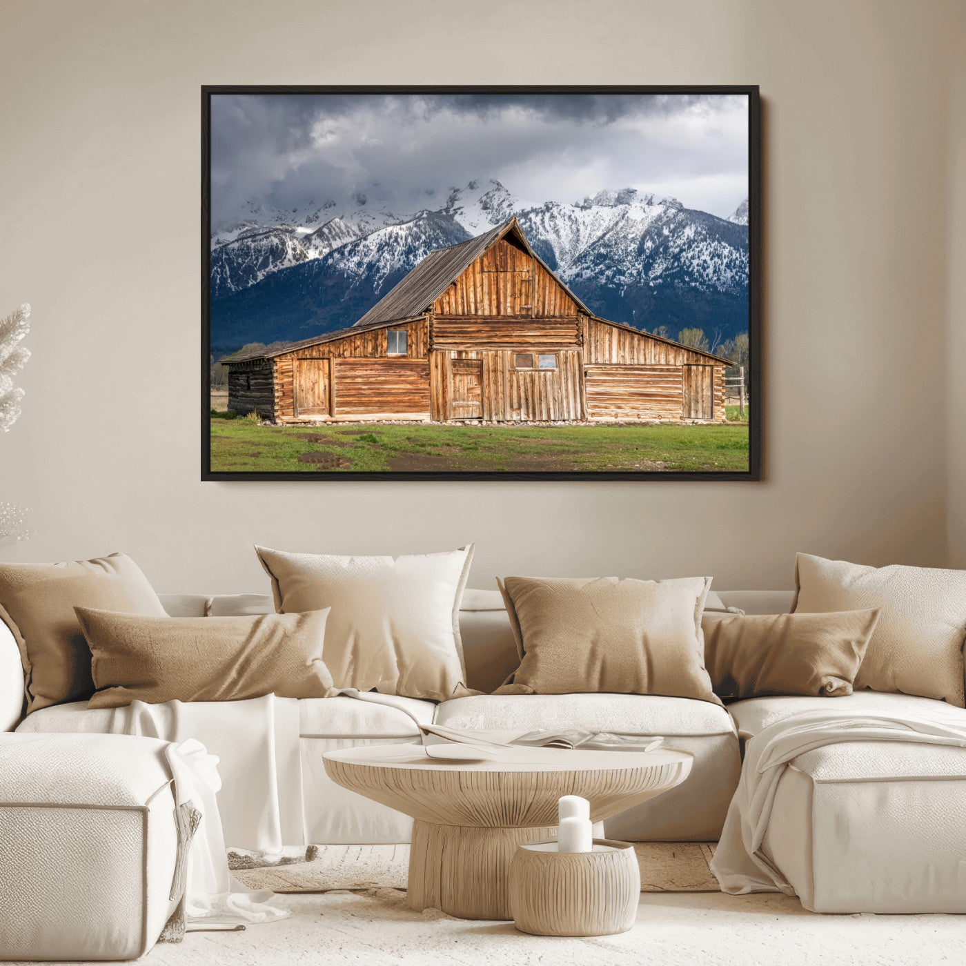 A stunning wall art canvas print featuring a rustic wooden barn set against a backdrop of snow-capped mountains under a dramatic cloudy sky, perfect for adding a touch of rural charm to any space.