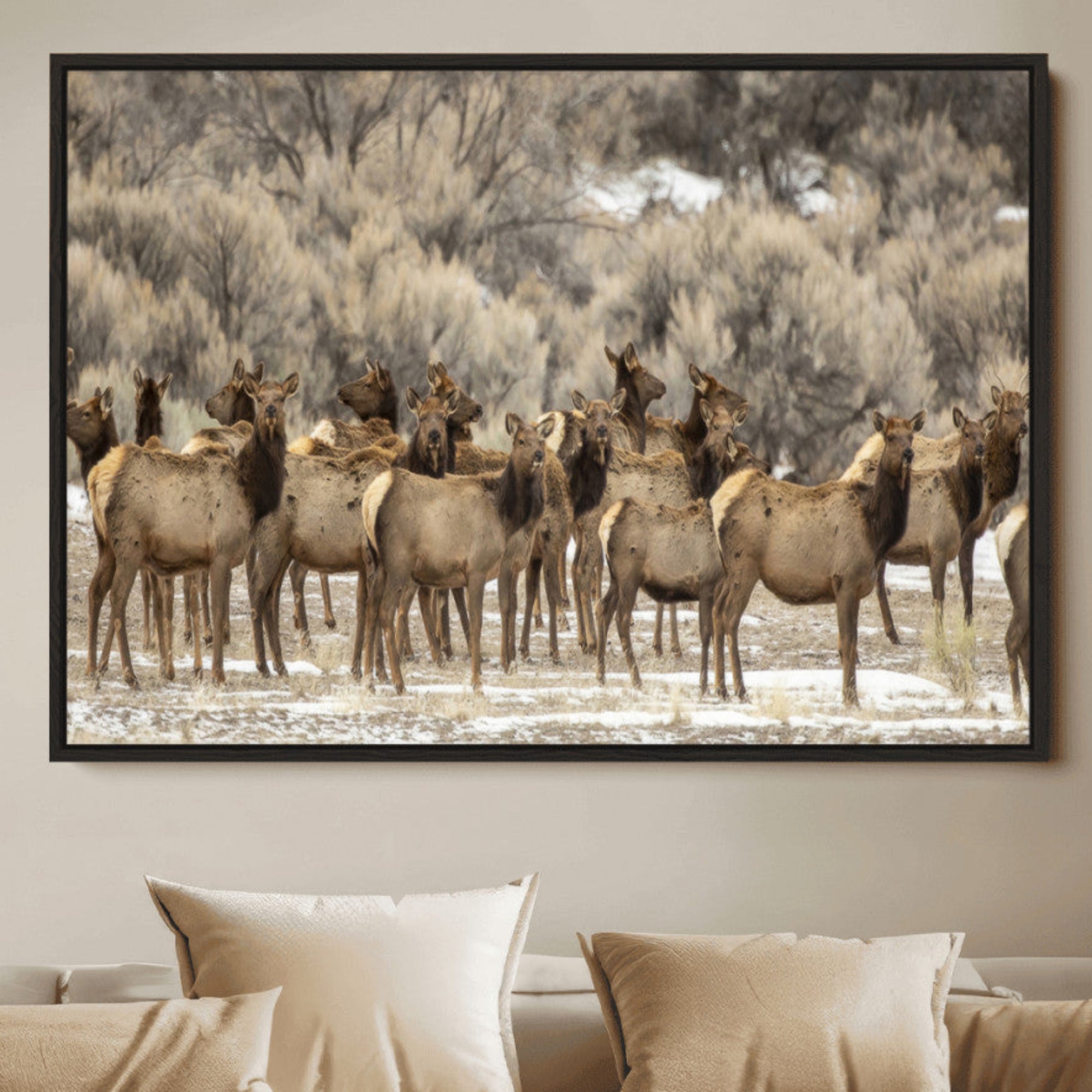 A stunning wall art canvas print featuring a large herd of elk standing together in a natural winter landscape with muted earthy tones and soft background foliage, perfect for rustic or nature-inspired home decor.