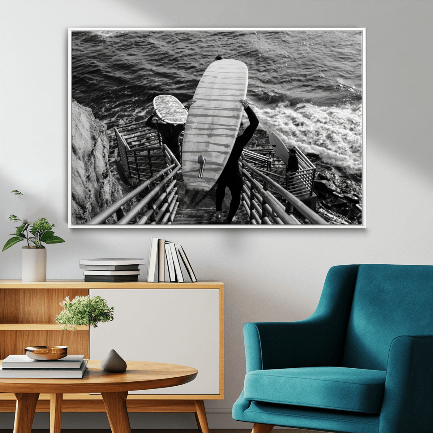 Black and white photo of surfers carrying boards down a rugged cliffside stairway, capturing a bold and adventurous coastal scene.