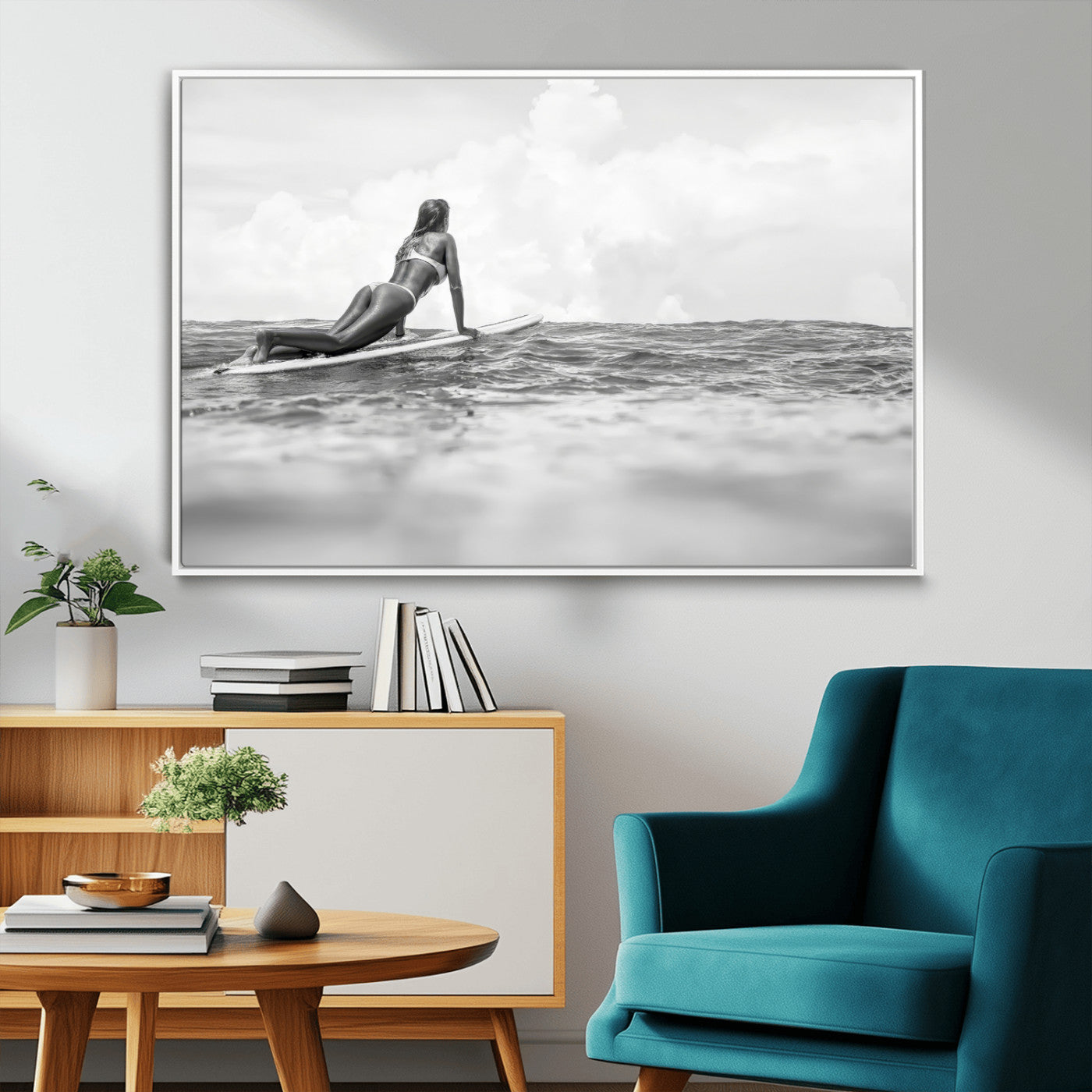 A black and white ocean scene featuring a surfer girl waiting on her board, gazing at the horizon, capturing a tranquil and adventurous coastal moment.