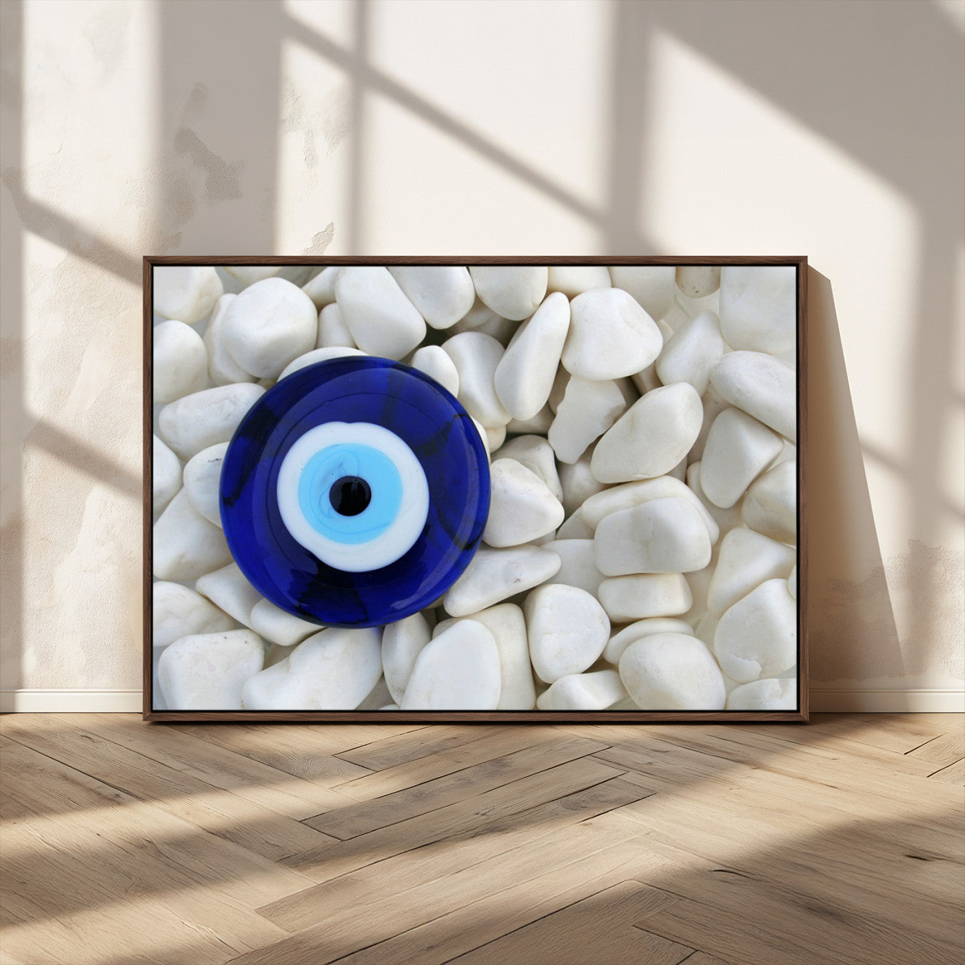 A close-up of a blue evil eye charm placed on white pebbles, symbolizing protection and good luck.