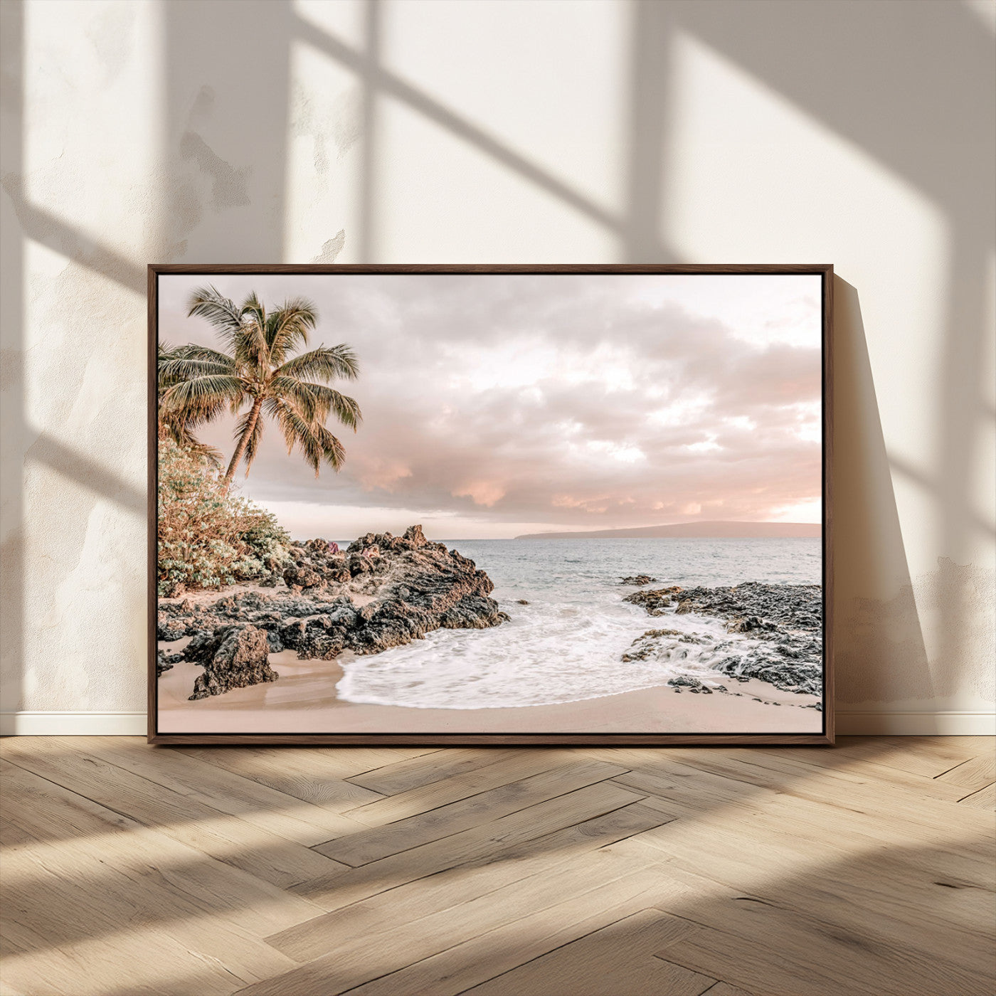 A peaceful beach scene with a palm tree and rocks, soft waves washing onto the shore under a soft pastel sky at sunset.
