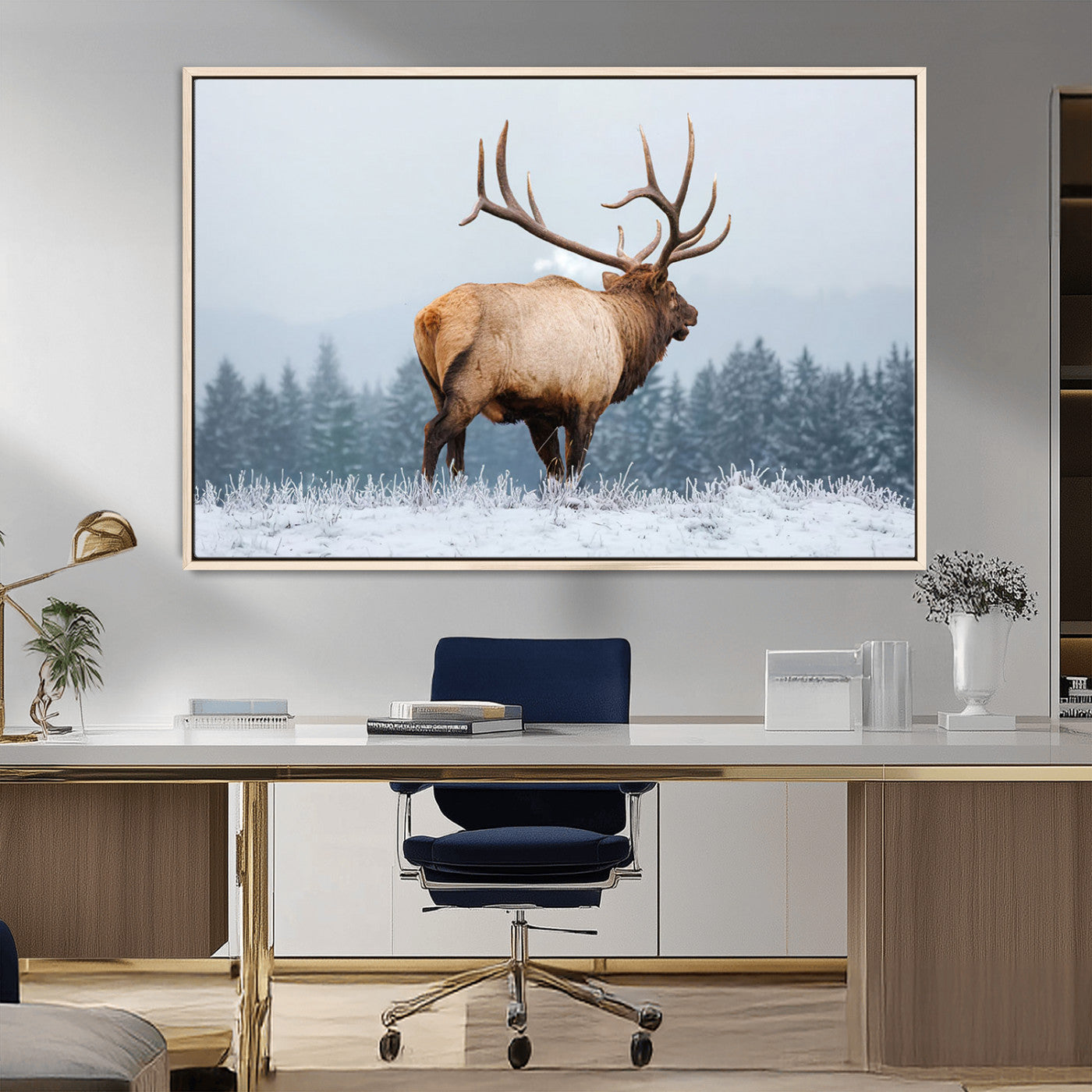 A majestic elk standing in a snowy landscape, with large antlers, set against a backdrop of evergreen trees and a soft winter sky.
