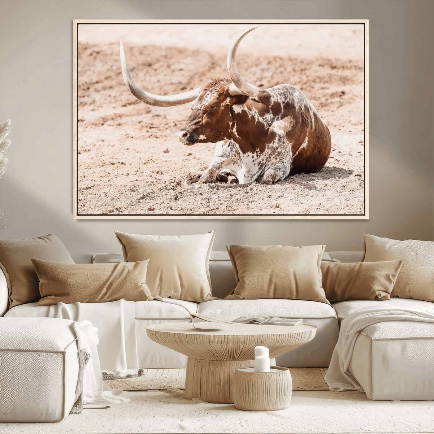 Texas Longhorn bull resting on dusty ground with warm tones, ideal for rustic western or farmhouse-themed wall decor.