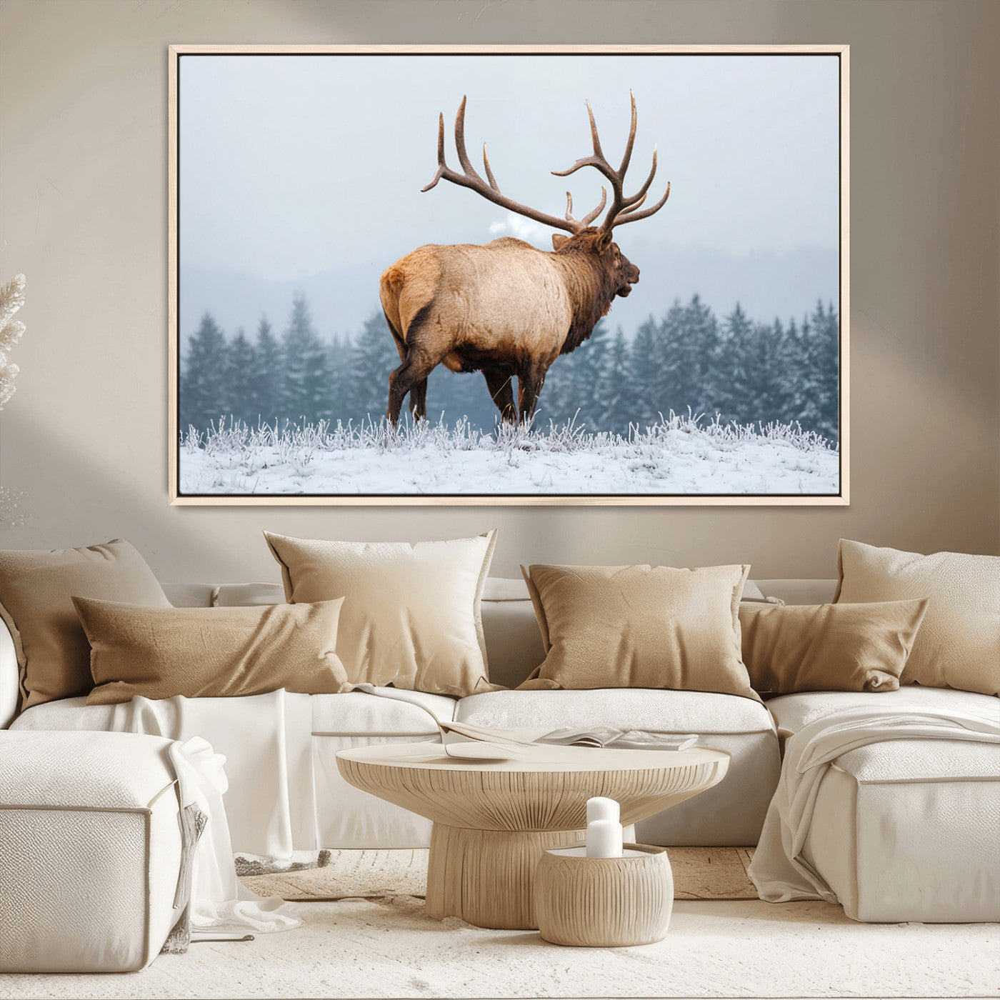 A majestic elk standing in a snowy landscape, with large antlers, set against a backdrop of evergreen trees and a soft winter sky.