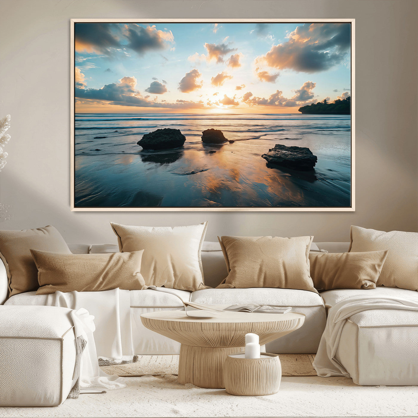 A serene beach at sunset with vibrant clouds, calm water, and rocks in the foreground reflecting the warm colors of the setting sun.