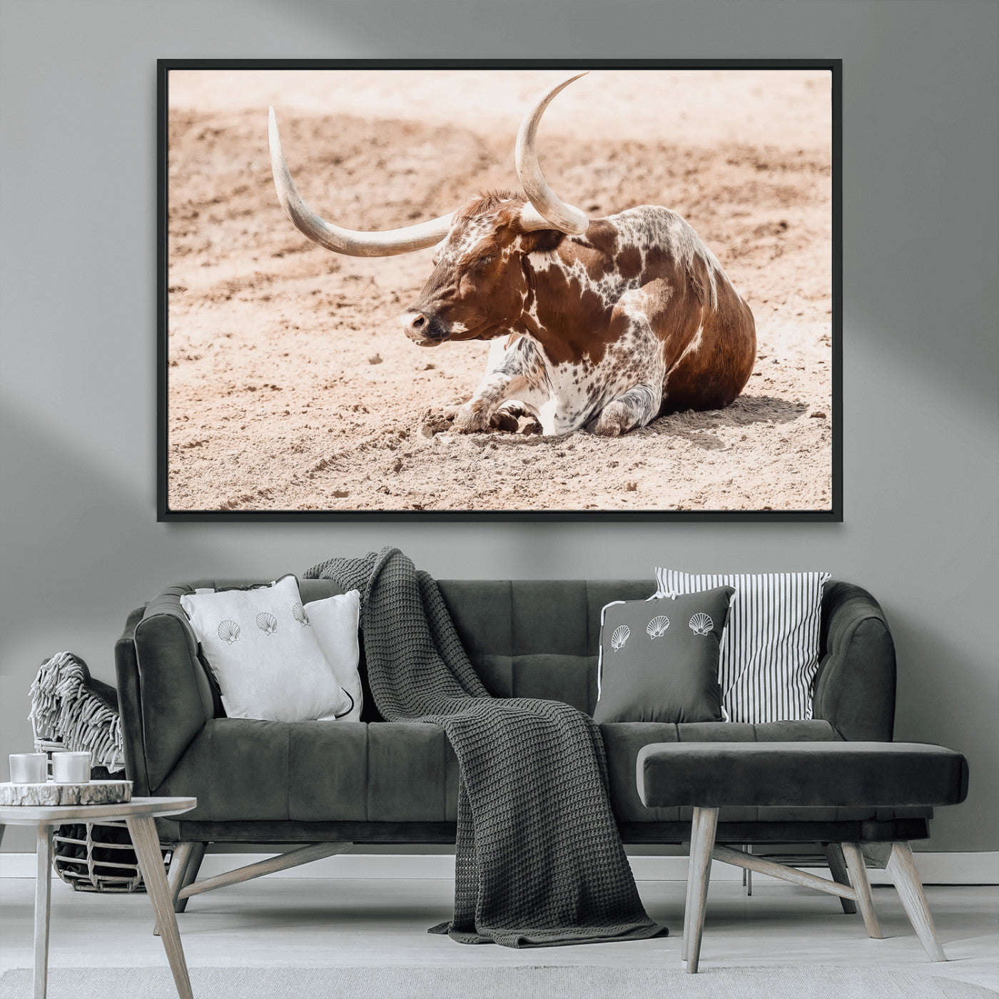 Texas Longhorn bull resting on dusty ground with warm tones, ideal for rustic western or farmhouse-themed wall decor.