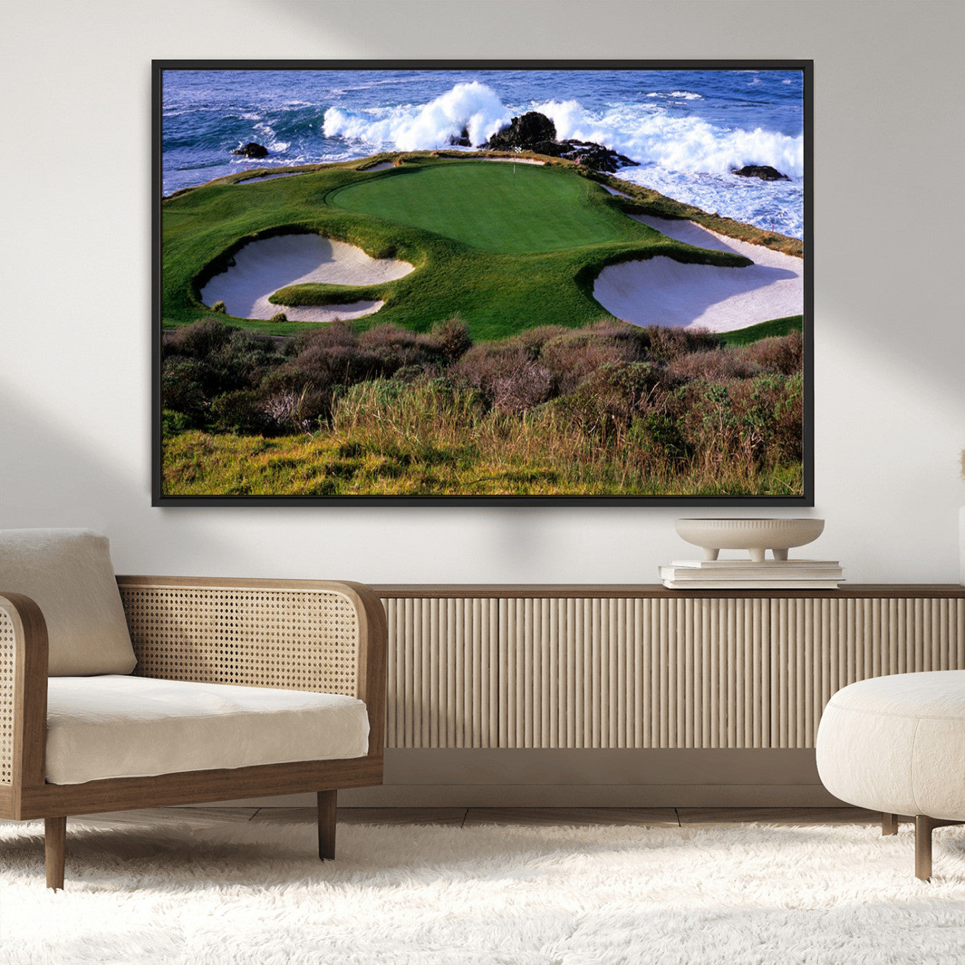 A scenic golf course located by the ocean, featuring a well-manicured green surrounded by sand traps and powerful ocean waves crashing on the shore.
