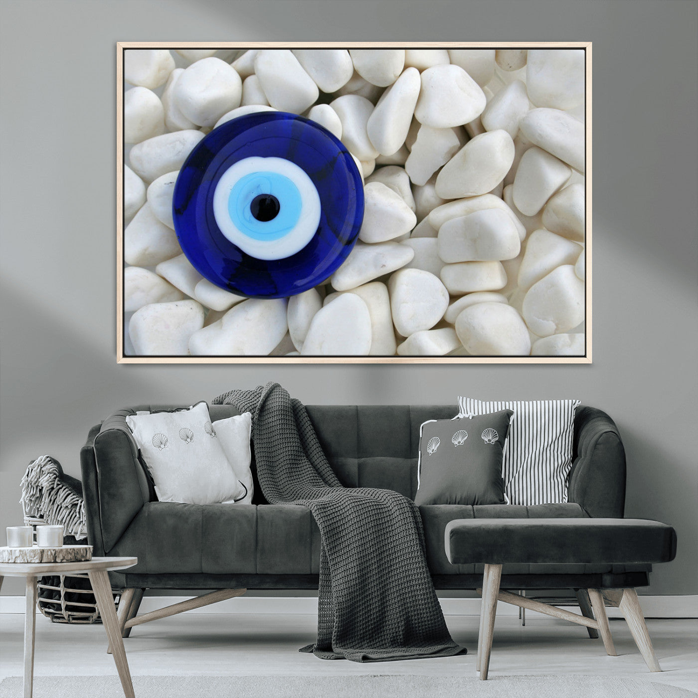 A close-up of a blue evil eye charm placed on white pebbles, symbolizing protection and good luck.