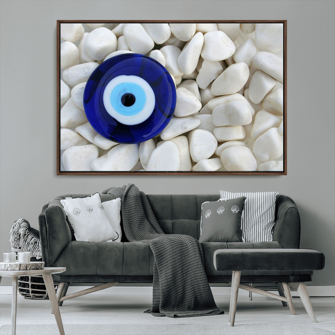 A close-up of a blue evil eye charm placed on white pebbles, symbolizing protection and good luck.