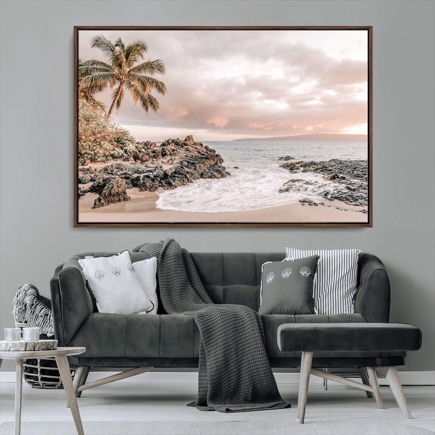A peaceful beach scene with a palm tree and rocks, soft waves washing onto the shore under a soft pastel sky at sunset.