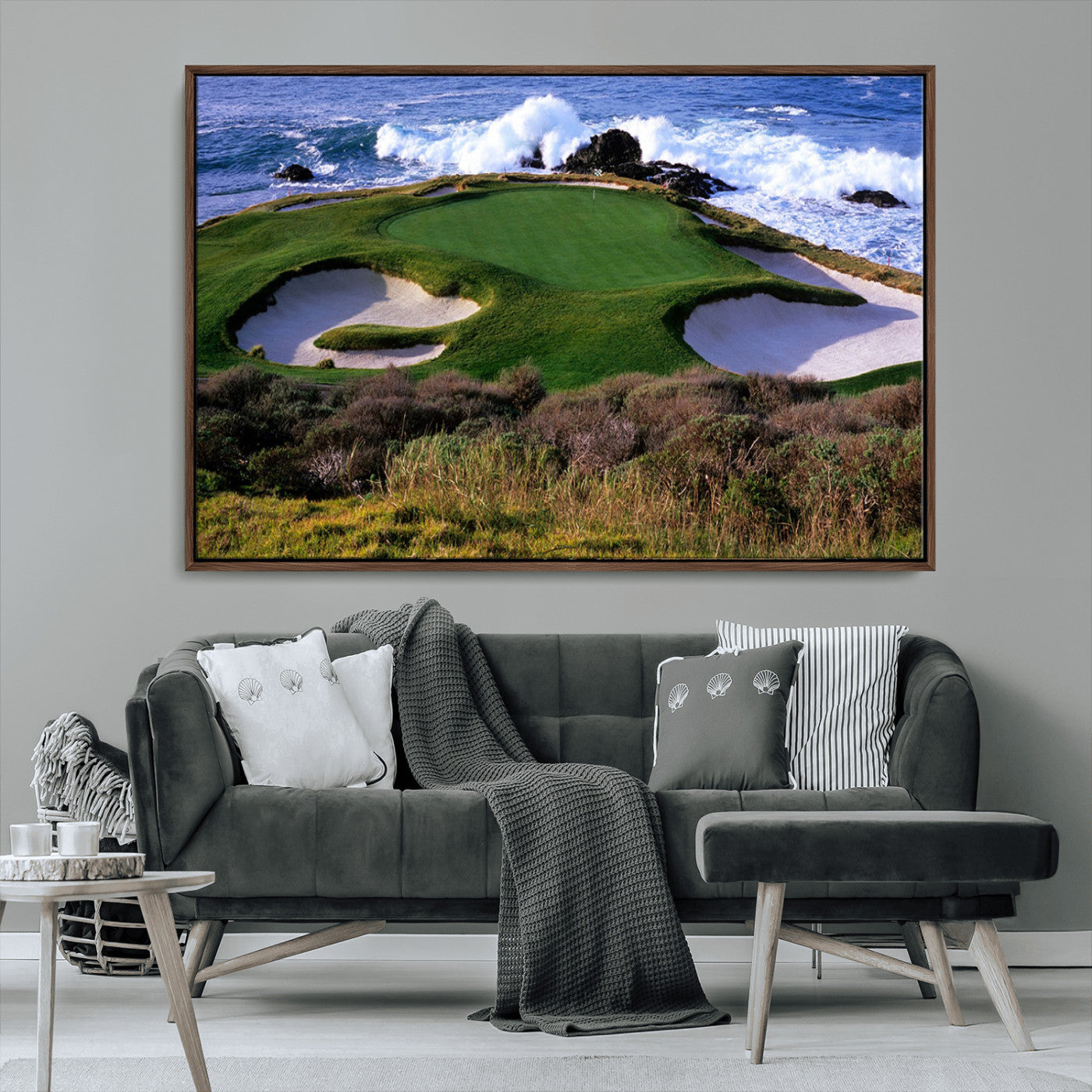 A scenic golf course located by the ocean, featuring a well-manicured green surrounded by sand traps and powerful ocean waves crashing on the shore.