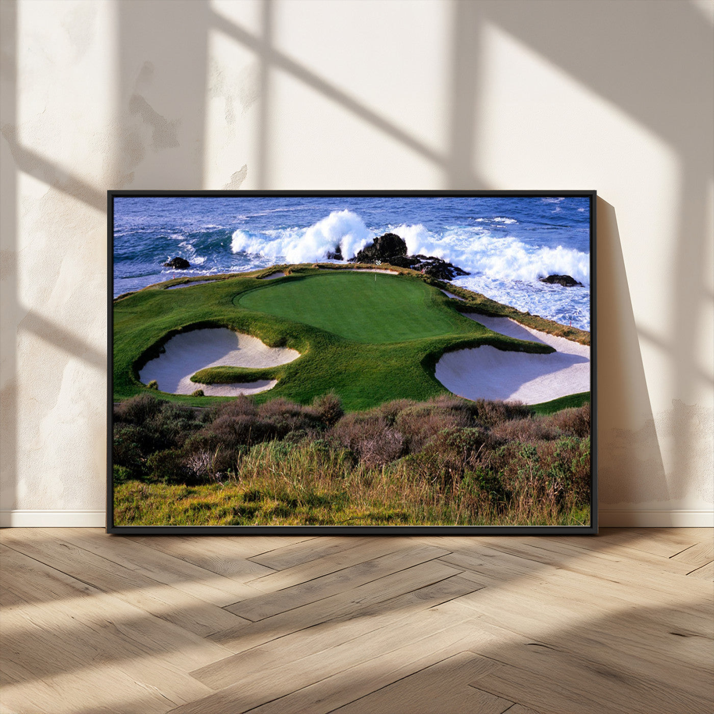A scenic golf course located by the ocean, featuring a well-manicured green surrounded by sand traps and powerful ocean waves crashing on the shore.