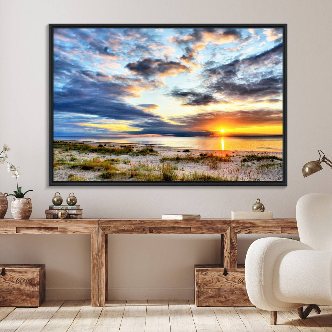 The Sunset On The Ocean canvas wall art features a beautiful beach sunset with grass and clouds.