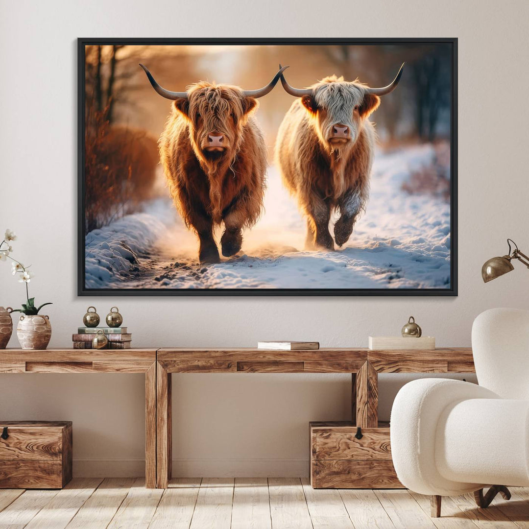 The wall art is a Scottish Highland Cow Horn canvas print featuring cows on a snowy path bathed in warm sunlight, serving as a rustic decor piece.