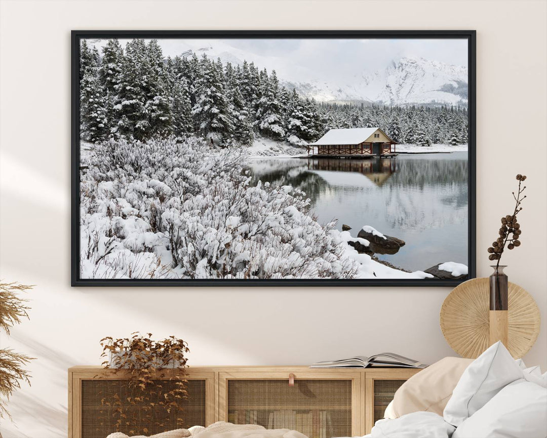 Experience the beauty of winter with the "Cabin by the Lake Canvas Wall Art," showcasing a serene snowy landscape. This rustic nature decor features a cozy cabin nestled amid snow-laden trees, set against a breathtaking mountain view, perfect for enhancing your living room.