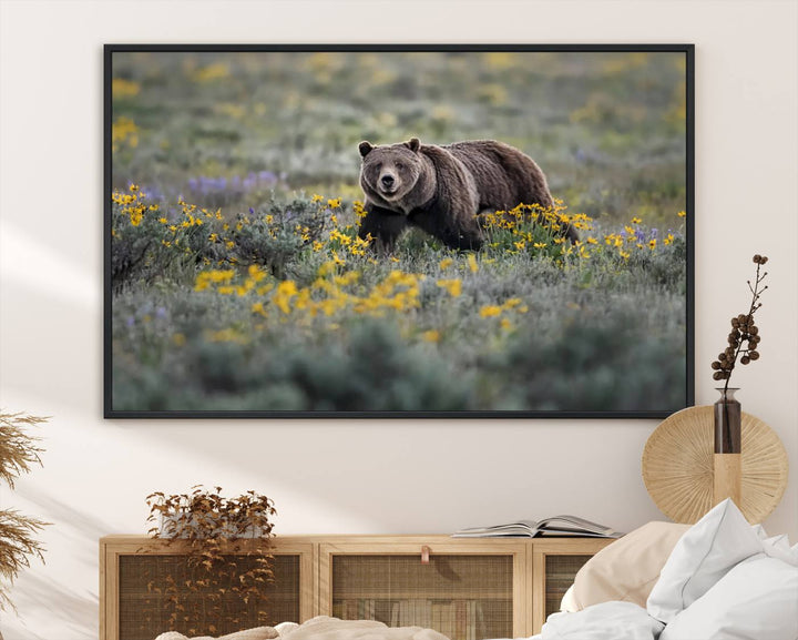 The "Grizzly 399 in Wild Flowers Wall Art Canvas Print" features a grizzly bear strolling through a field of yellow and purple flowers, beautifully showcased as a triptych. This handcrafted piece, proudly made in the USA, adds charm and sophistication to your space.