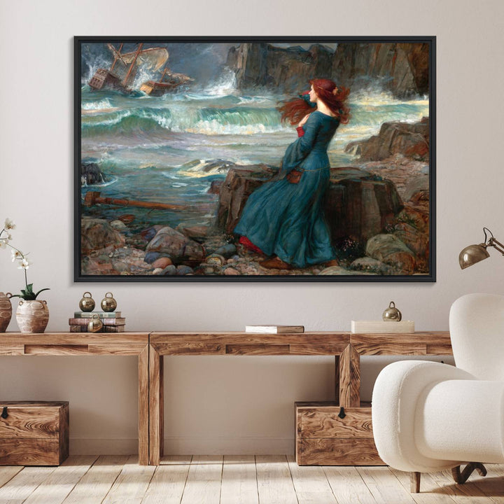 The Miranda by the Shore Wall Art Canvas Print depicts a woman in a blue dress standing by the sea, watching a shipwreck.