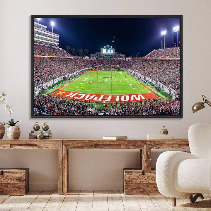 A NC State Wolfpack Football Team print of Carter-Finley Stadium at night features WOLFPACK illuminated brightly in the end zone grass.