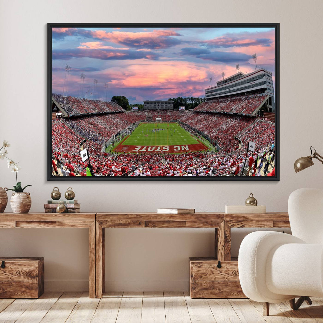 The wall art captures an NC State Wolfpack game under a vibrant sunset on triple canvas.