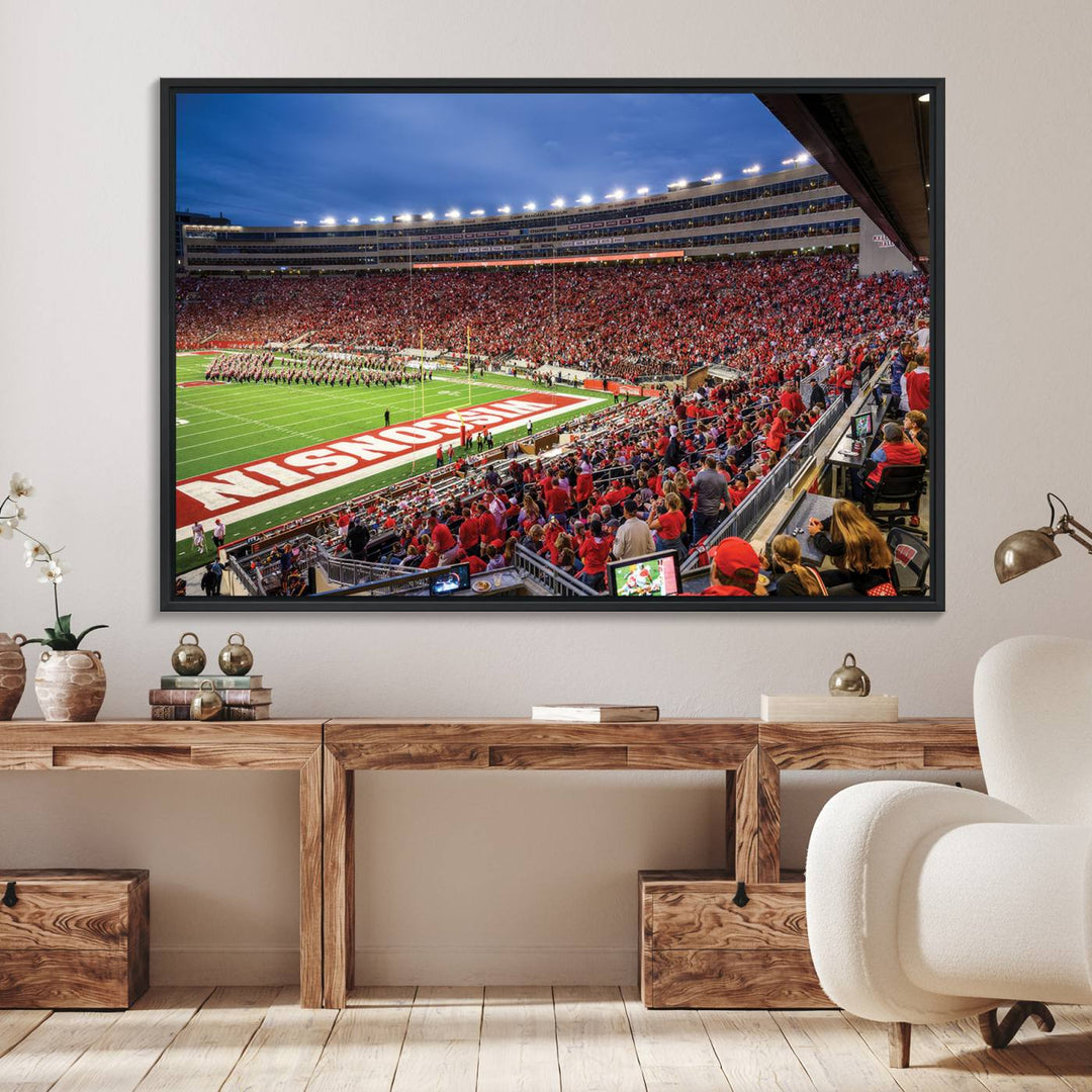 A vibrant wall art captures the essence of Madison Camp Randall Stadium, depicting a sea of fans in red and white during a Wisconsin Badgers football game under bright lights.