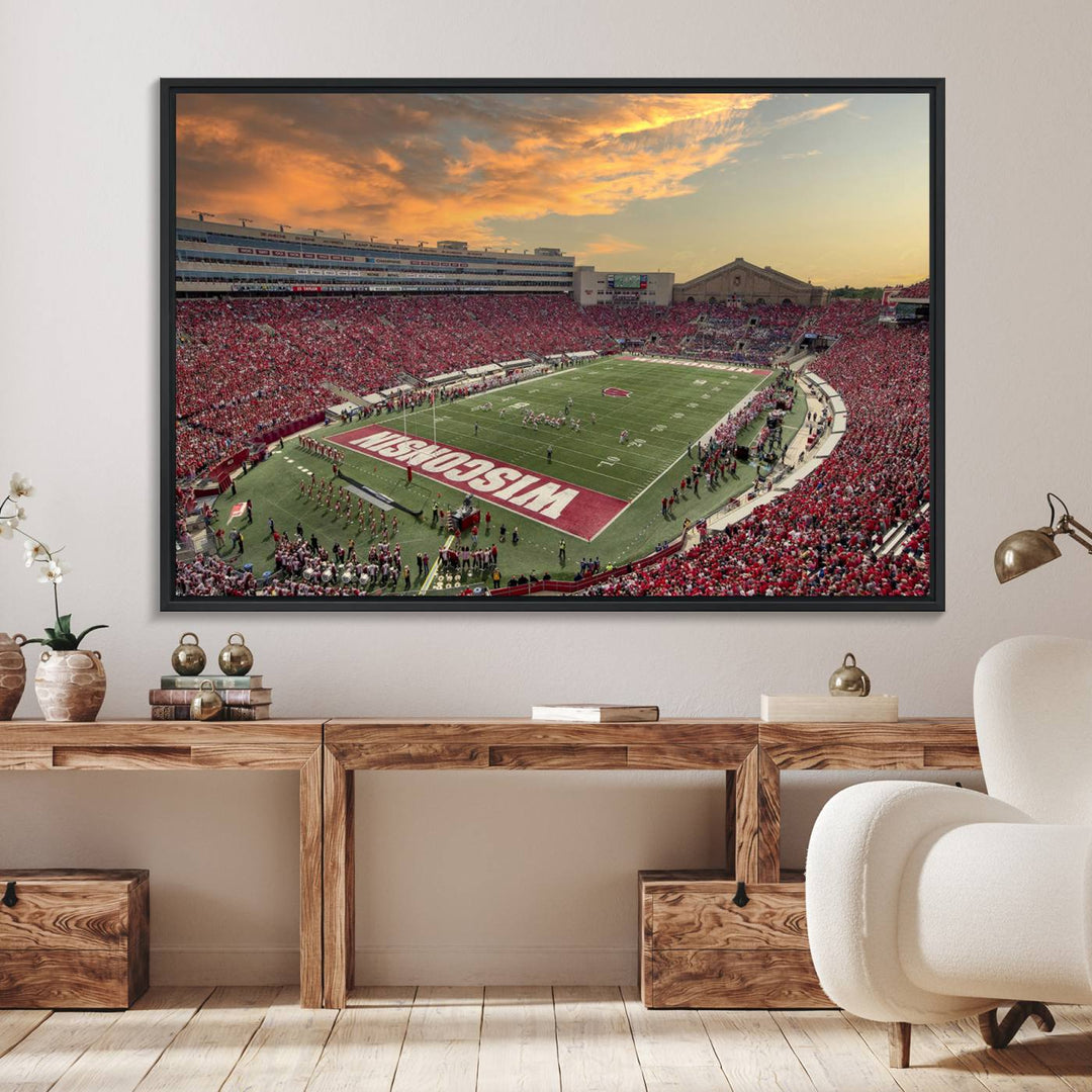 The wall features a Wisconsin Badgers wall art canvas print, capturing the vibrant atmosphere of a full Camp Randall Stadium at sunset.