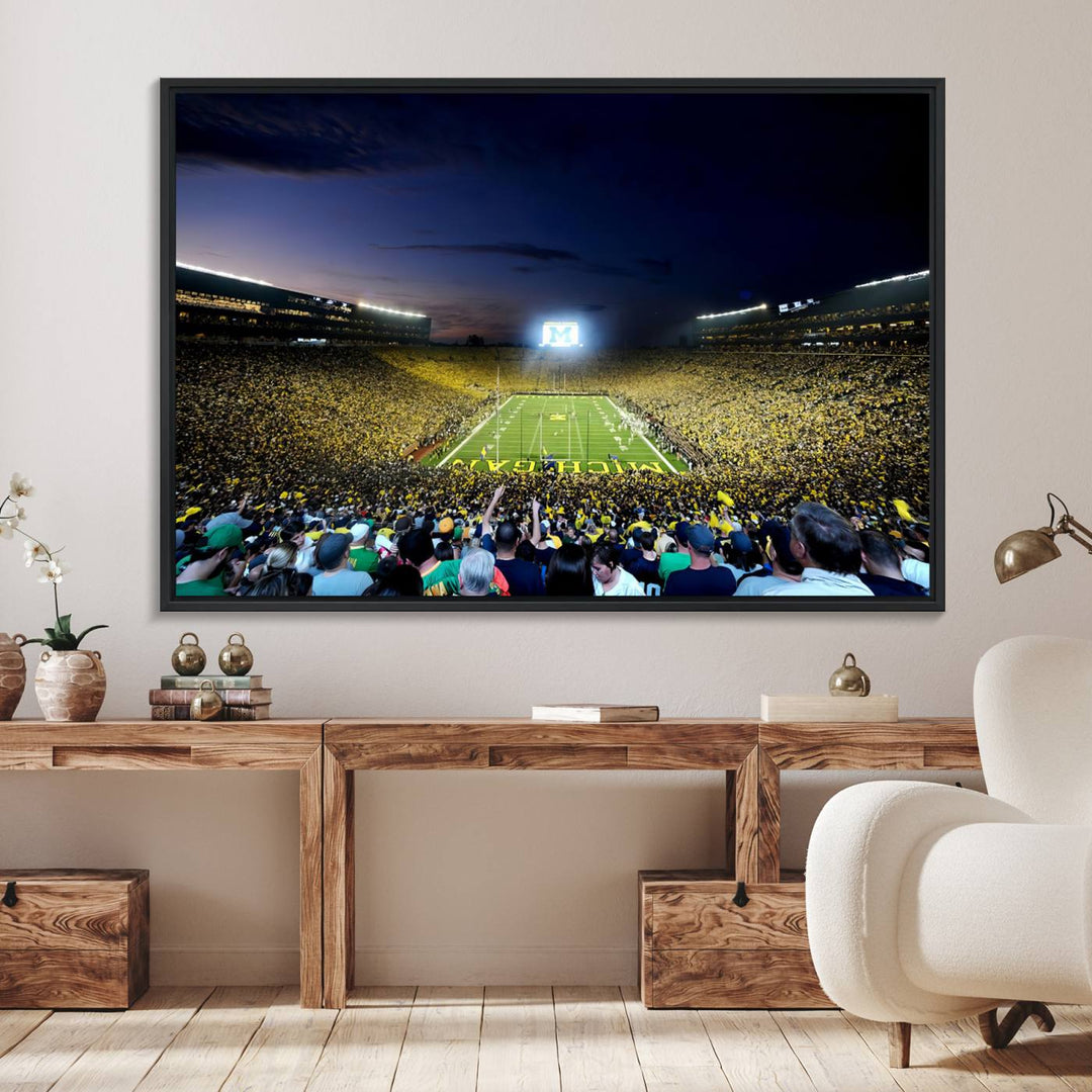 The wall art features a glowing M in this Michigan Wolverines Football Team Ann Arbor Stadium Canvas Print.