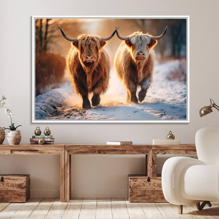 The wall art is a Scottish Highland Cow Horn canvas print featuring cows on a snowy path bathed in warm sunlight, serving as a rustic decor piece.