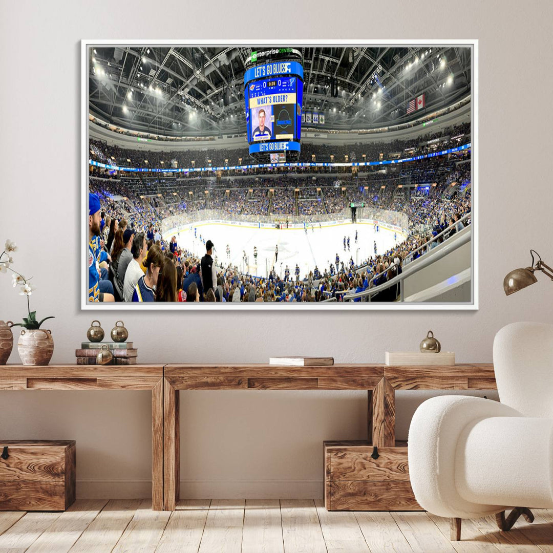 Wall art prints depicting the bustling scenes of the St. Louis Blues being cheered on by a full house at the Enterprise Center, beneath a large scoreboard.