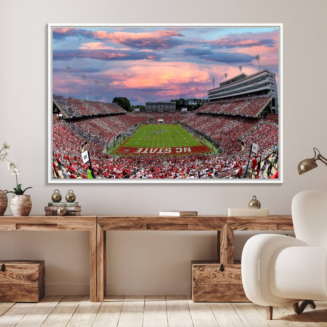 The wall art captures an NC State Wolfpack game under a vibrant sunset on triple canvas.