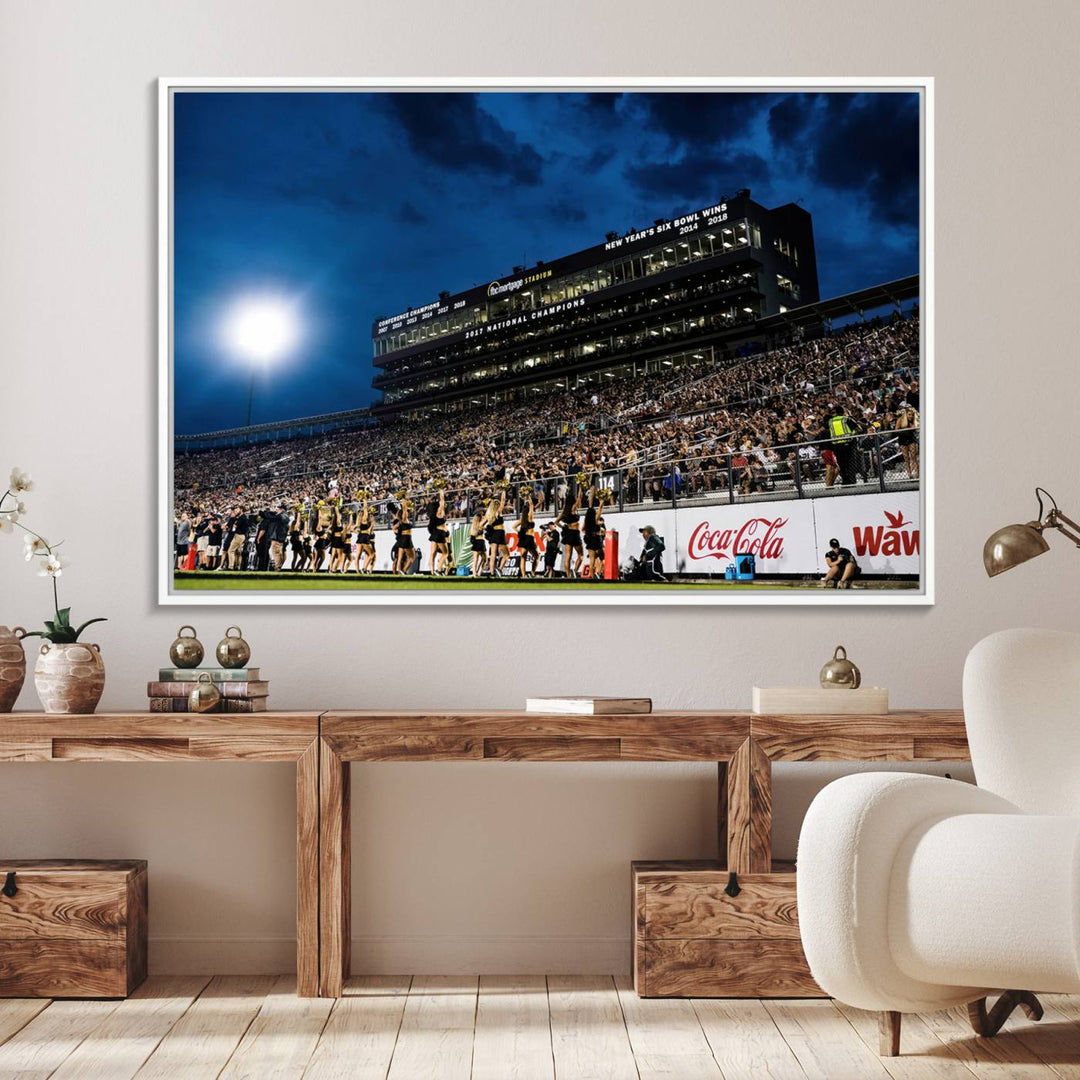 A gallery-quality canvas print depicting a stadium packed with fans under a night sky, highlighting the UCF Knights Football Team.