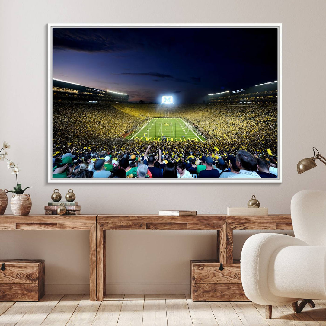 The wall art features a glowing M in this Michigan Wolverines Football Team Ann Arbor Stadium Canvas Print.