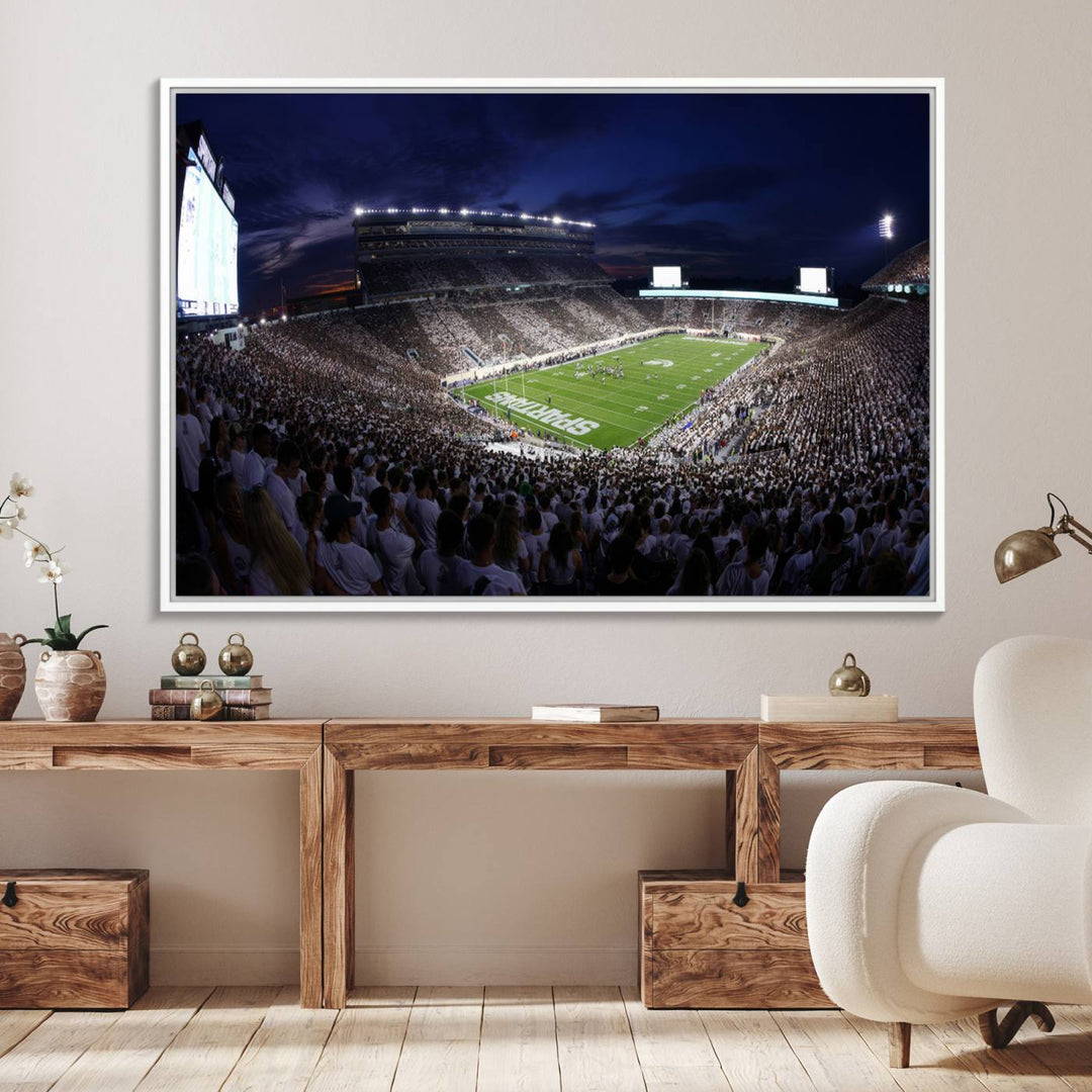 A packed football stadium at night, with bright lights and fans in white, depicted in a Michigan State Spartans Stadium wall art.