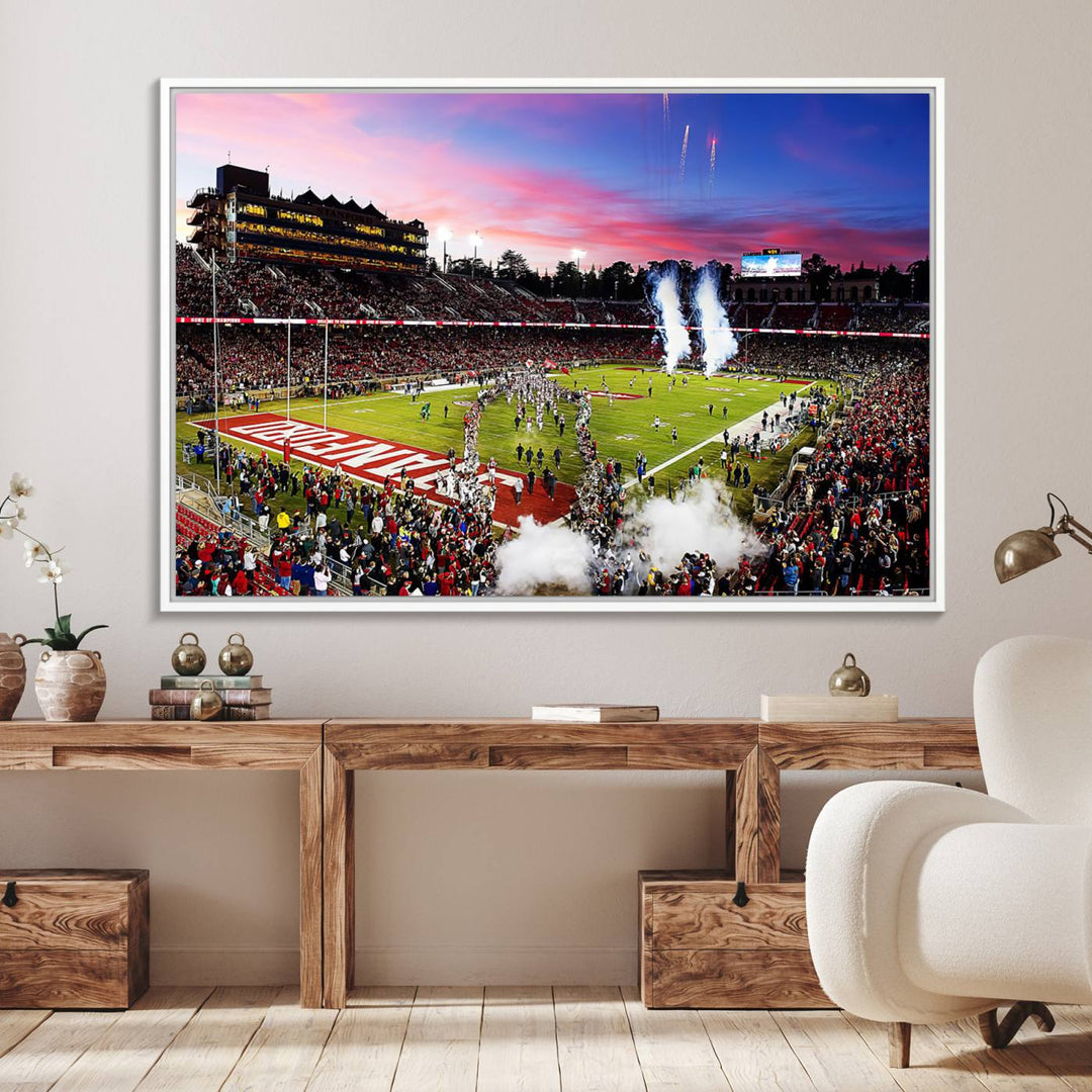 The wall art features a canvas print of the Stanford Cardinal football team, capturing players, fireworks, and smoke against the backdrop of a sunset at Stanford Stadium.