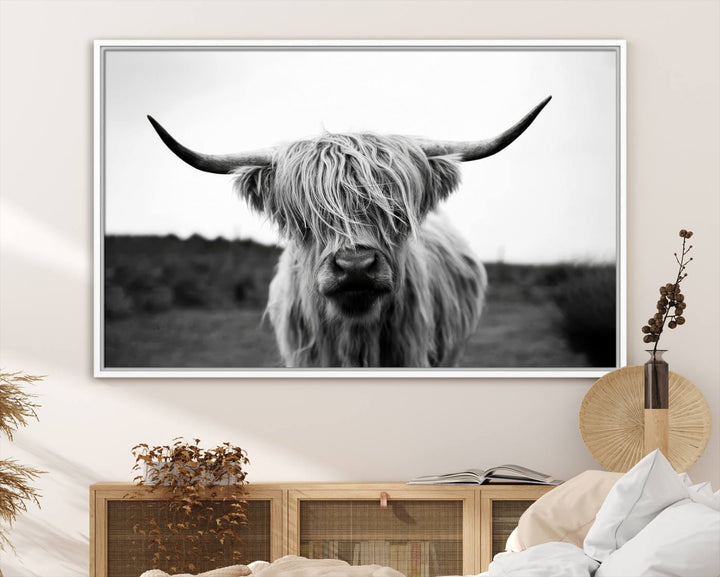 The Highland Cow Wall Art, a black and white farmhouse decor piece showcased as a triptych canvas print, graces a dark wall with its long-haired Scottish Highland cattle art print exuding rustic barn aesthetic.