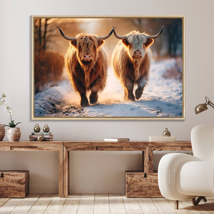 The wall art is a Scottish Highland Cow Horn canvas print featuring cows on a snowy path bathed in warm sunlight, serving as a rustic decor piece.