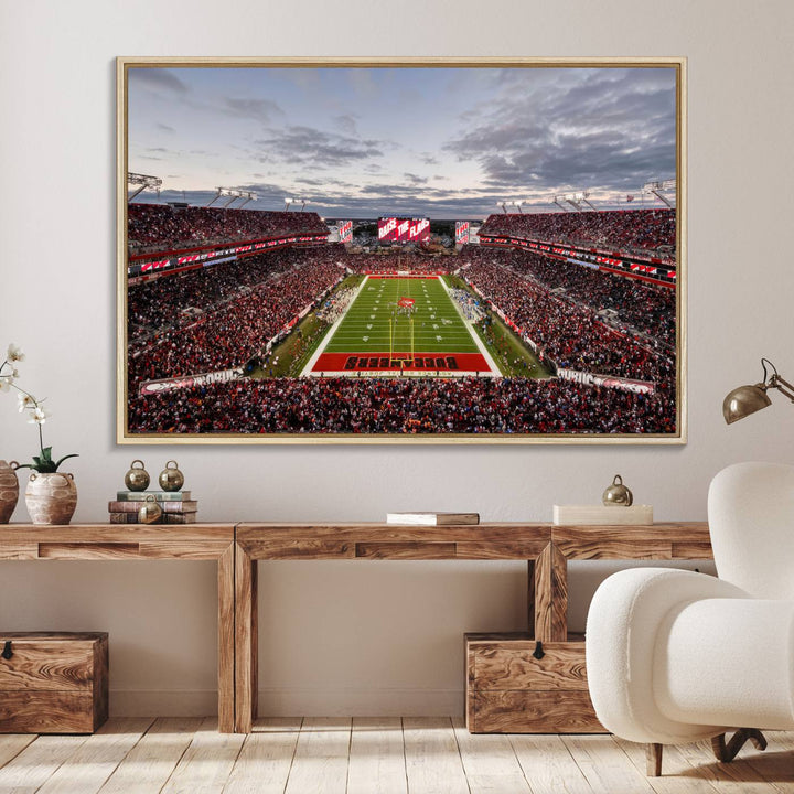 The wall art captures a stunning scene of Raymond James Stadium bathed in the warm hues of sunset. The sky, filled with clouds, provides a dramatic contrast to the vibrant lighting on the field, encapsulating the dynamic energy of a football game.