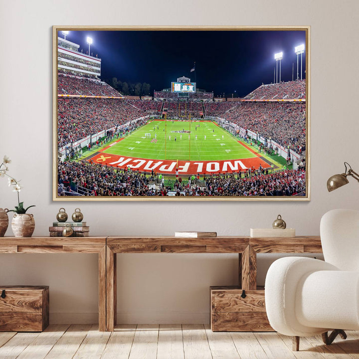 A NC State Wolfpack Football Team print of Carter-Finley Stadium at night features WOLFPACK illuminated brightly in the end zone grass.