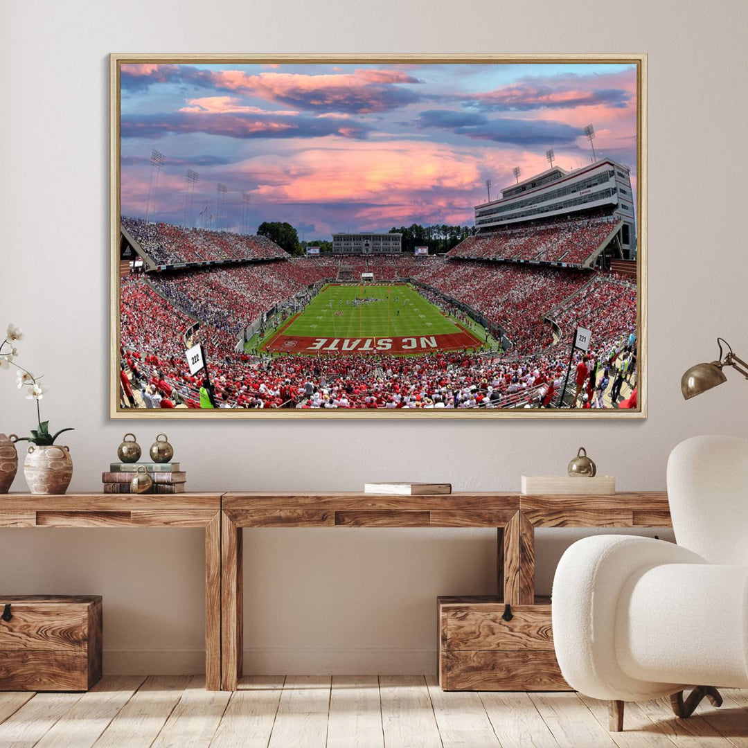 The wall art captures an NC State Wolfpack game under a vibrant sunset on triple canvas.