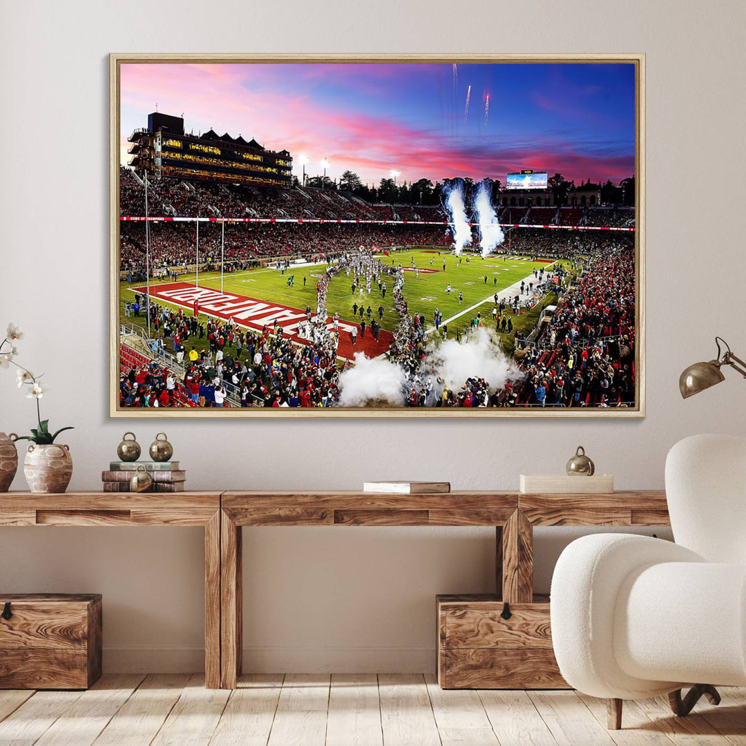 The wall art features a canvas print of the Stanford Cardinal football team, capturing players, fireworks, and smoke against the backdrop of a sunset at Stanford Stadium.