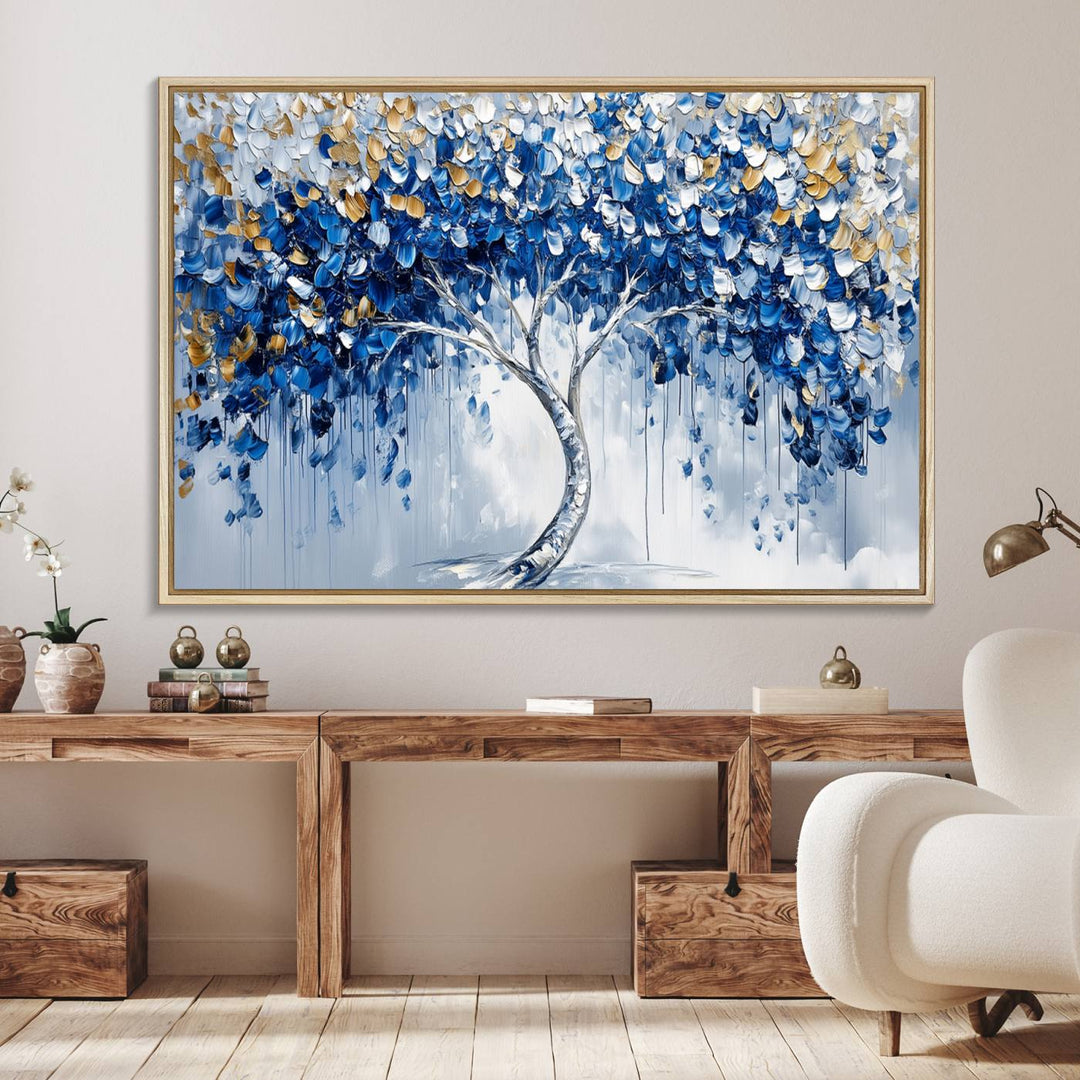 The Blue and Gold Abstract Tree Wall Art showcases a swirl trunk and features blue, silver, and gold leaves on a framed canvas print.