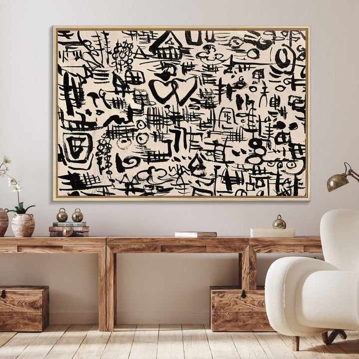 The Abstract Love and Chaos canvas is a museum-quality print featuring black symbols on a beige background, adorned with a heart and scribble design. It is framed to enhance its artistic appeal.