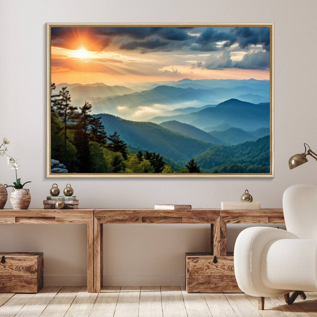 The wall art, titled Sunrise Over Mountain Range, is a canvas print that beautifully depicts layers of hills, scattered trees, and a partly cloudy sky.