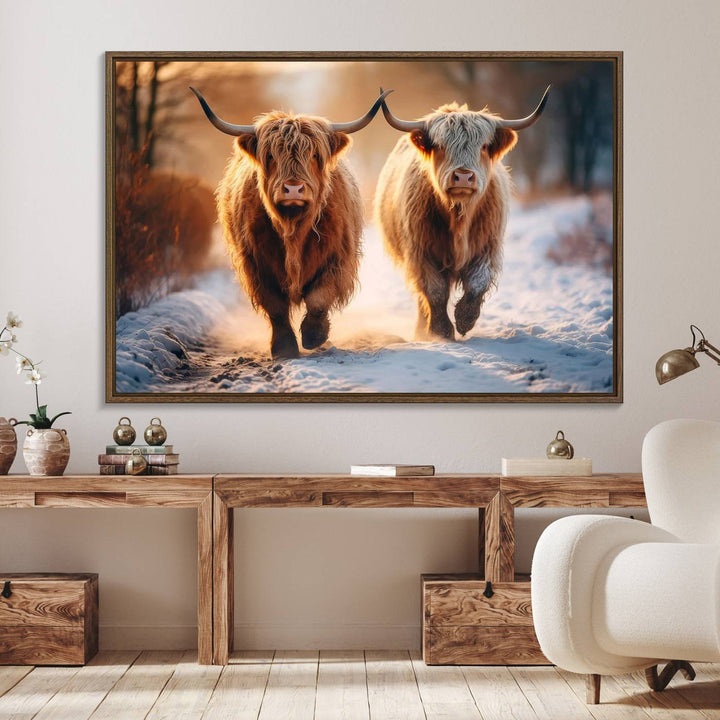 The wall art is a Scottish Highland Cow Horn canvas print featuring cows on a snowy path bathed in warm sunlight, serving as a rustic decor piece.