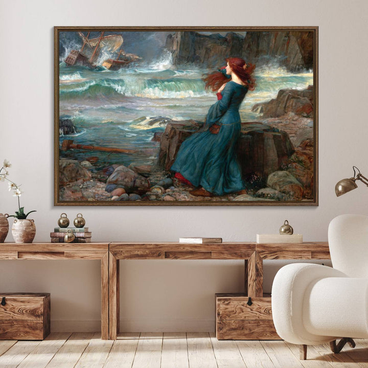 The Miranda by the Shore Wall Art Canvas Print depicts a woman in a blue dress standing by the sea, watching a shipwreck.