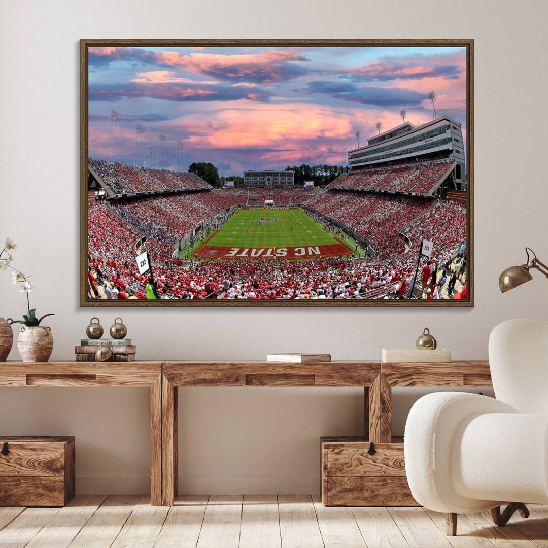 The wall art captures an NC State Wolfpack game under a vibrant sunset on triple canvas.