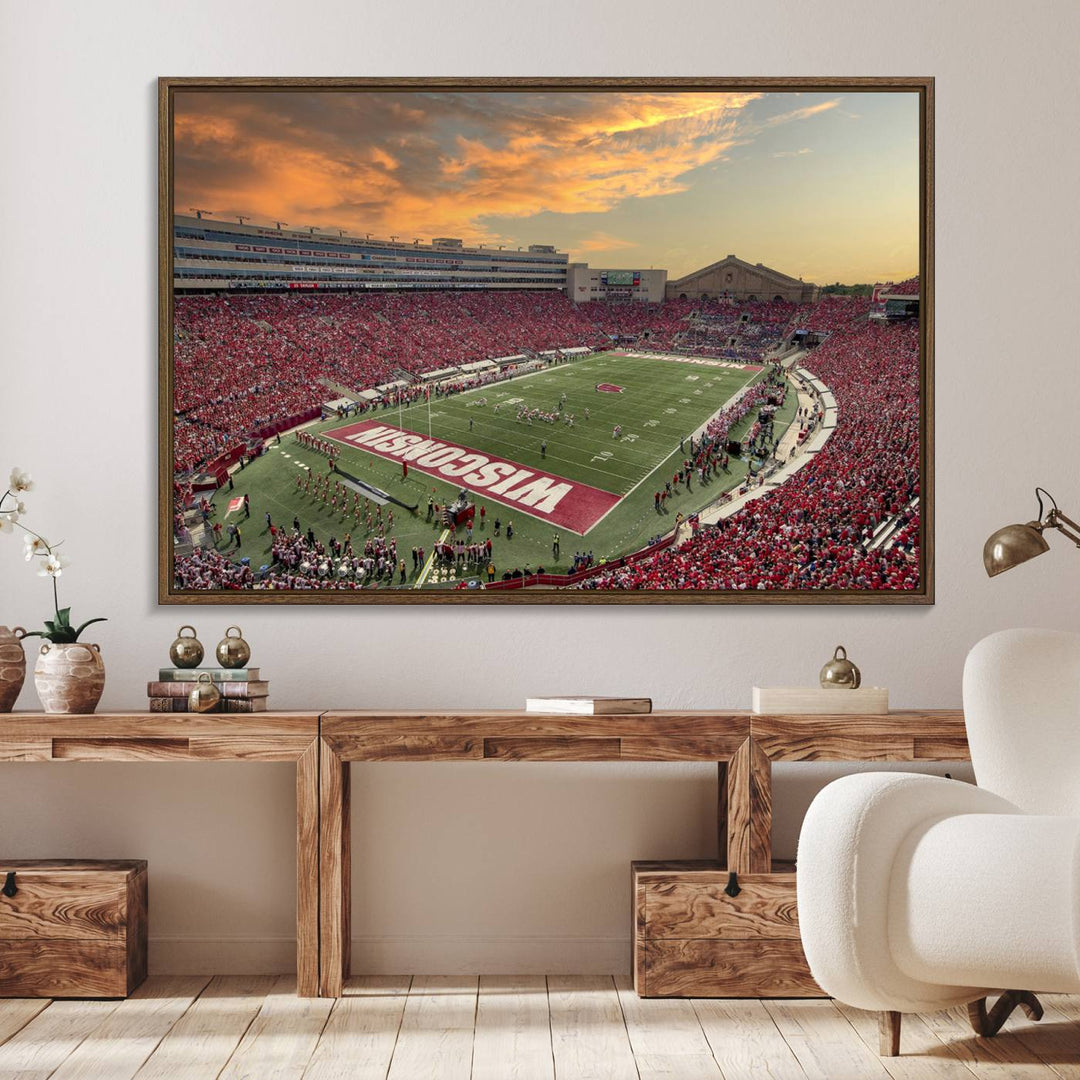 The wall features a Wisconsin Badgers wall art canvas print, capturing the vibrant atmosphere of a full Camp Randall Stadium at sunset.