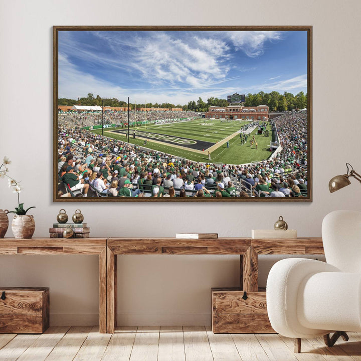 The University of Charlotte 49ers stadium print adds flair to a modern living room wall with its vibrant scene and clear sky.