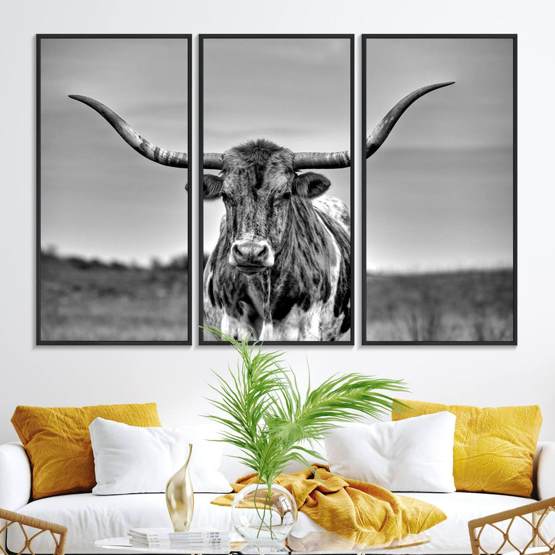 The Texas Longhorn Cow wall art, divided into three panels, is of gallery quality and displayed on a dark wall.