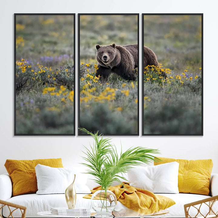 The "Grizzly 399 in Wild Flowers Wall Art Canvas Print" features a grizzly bear strolling through a field of yellow and purple flowers, beautifully showcased as a triptych. This handcrafted piece, proudly made in the USA, adds charm and sophistication to your space.